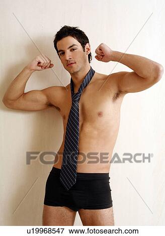 Stock Photo - Bare chested young man posing with shorts and tie. Fotosearch