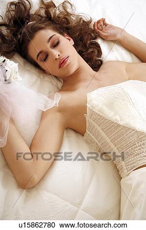 Bride lying down on wedding bed View Large Photo Image Stock Image - Bride lying down on wedding bed. Fotosearch