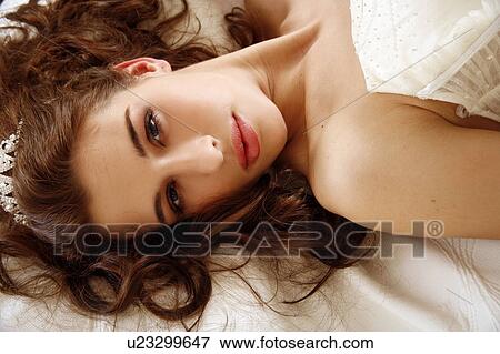 Bride lying down on wedding bed View Large Photo Image Stock Photo - Bride lying down on wedding bed. Fotosearch