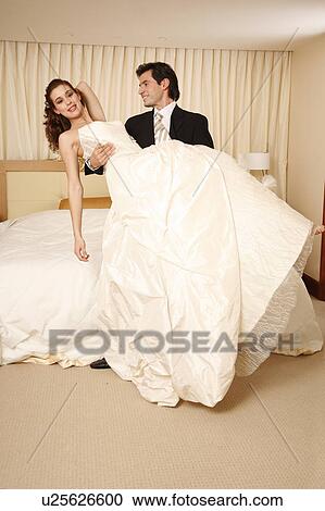 Groom holding bride in his arms in hotel room View Large Photo Image Stock Image - Groom holding bride in his arms in hotel room. Fotosearch