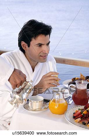Stock Image - Man having breakfast on hotel terrace. Fotosearch