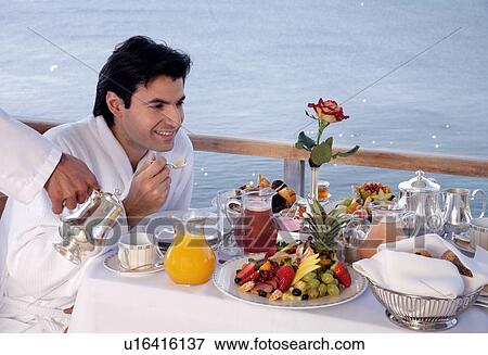 Stock Photo - Man having breakfast on hotel terrace. Fotosearch
