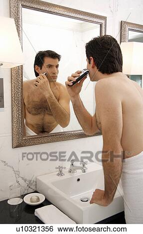 Man shaving in the bathroom mirror View Large Photo Image Stock Photograph - Man shaving in the bathroom mirror. Fotosearch