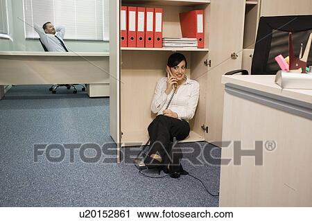Office worker on the phone hiding from manager View Large Photo Image Stock Image - Office worker on the phone hiding from manager. Fotosearch