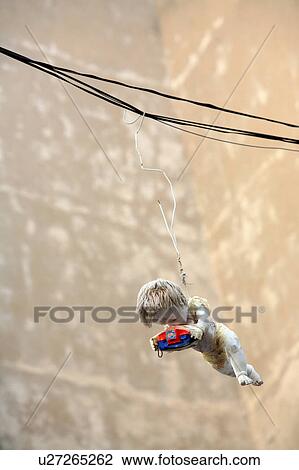 Stock Image - Old doll holding Viewmaster hanging in the air. Fotosearch