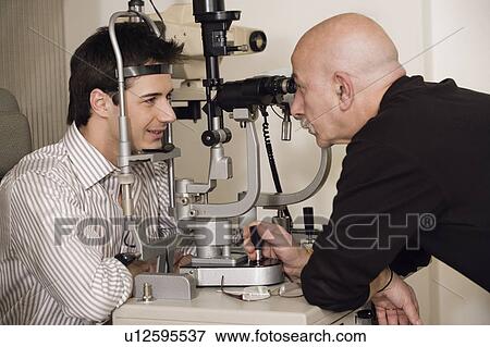 Stock Photo - Optometrist examining patient. Fotosearch
