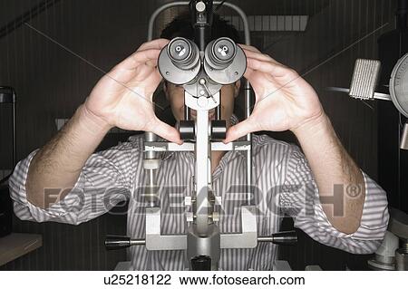 Stock Image - Patient at optometrist. Fotosearch