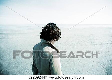 Stock Photo - Person looking out at sea. Fotosearch
