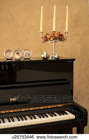 Piano decorated with photos and candelabra View Large Photo Image Stock Photograph - Piano decorated with photos and candelabra. Fotosearch