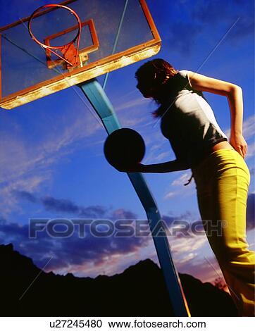 Stock Image - Woman playing basketball. Fotosearch
