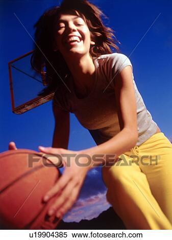 Stock Photography - Woman playing basketball. Fotosearch