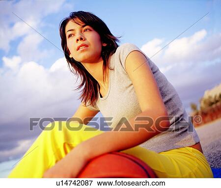 Stock Photo - Woman sitting with basketball. Fotosearch