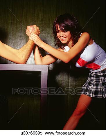 Young woman arm wrestling with man View Large Photo Image Stock Photography - Young woman arm wrestling with man. Fotosearch
