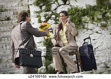 Stock Photography - Businessman giving businesswoman flowers. Fotosearch