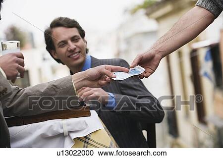 Stock Image - Businessmen at taverna paying bill. Fotosearch