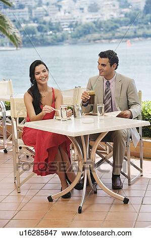Couple at seaside cafe table View Large Photo Image Stock Photo - Couple at seaside cafe table. Fotosearch