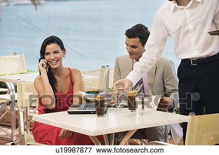 Couple at seaside cafe table with laptop View Large Photo Image Stock Photo - Couple at seaside cafe table with laptop. Fotosearch