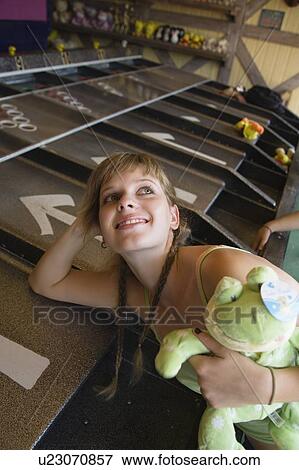Stock Photo - Female teenager leaning on game in amusement park. Fotosearch