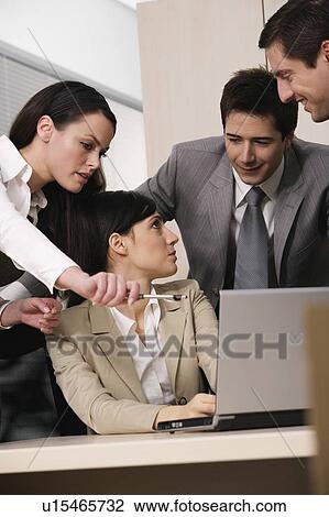 Stock Image - Four business people in office. Fotosearch