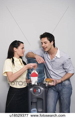 Male and female office workers eating take out food View Large Photo Image Stock Photo - Male and female office workers eating take out food. Fotosearch