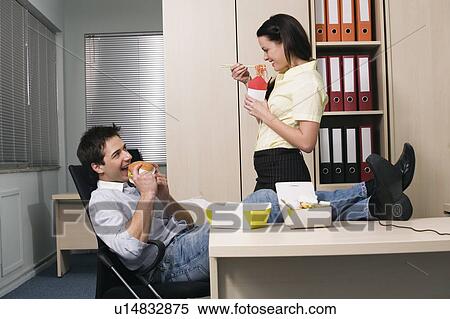 Male and female office workers eating take out food View Large Photo Image Stock Photography - Male and female office workers eating take out food. Fotosearch