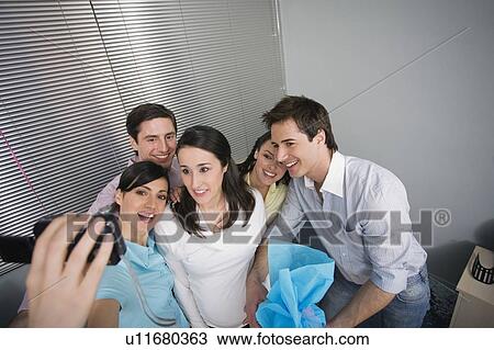 Stock Image - Office colleagues being photographed at party. Fotosearch