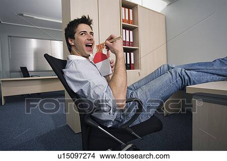Office worker eating Chinese food at desk View Large Photo Image Picture - Office worker eating Chinese food at desk. Fotosearch