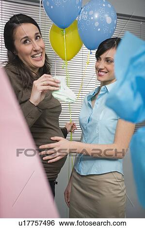 Stock Photograph - Pregnant office worker with colleague at party. Fotosearch