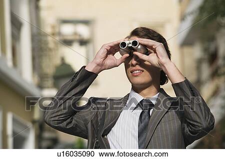 Stock Image - Professional looking through binoculars. Fotosearch