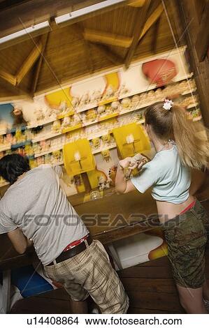 Teenage couple at game in amusement park View Large Photo Image Picture - Teenage couple at game in amusement park. Fotosearch