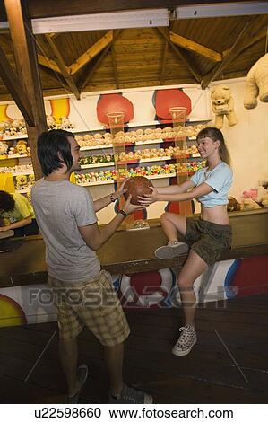 Teenage couple at game in amusement park View Large Photo Image Stock Image - Teenage couple at game in amusement park. Fotosearch