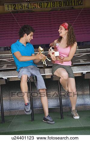 Teenage couple at game in amusement park View Large Photo Image Stock Image - Teenage couple at game in amusement park. Fotosearch