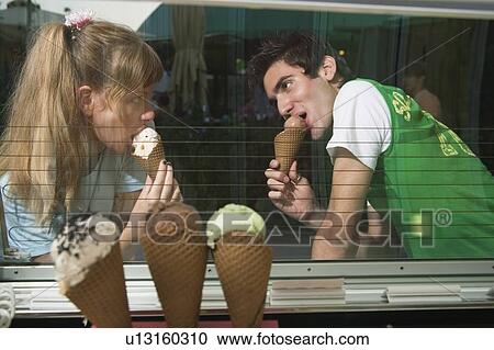 Stock Image - Teenage couple eating ice cream. Fotosearch