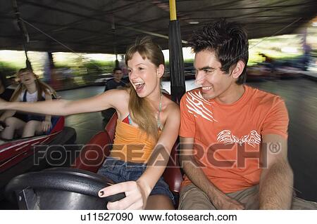 Teenage couple in bumper car in amusement park View Large Photo Image Stock Image - Teenage couple in bumper car in amusement park. Fotosearch