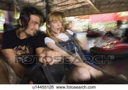 Stock Photograph - Teenage couple in bumper car in amusement park. Fotosearch