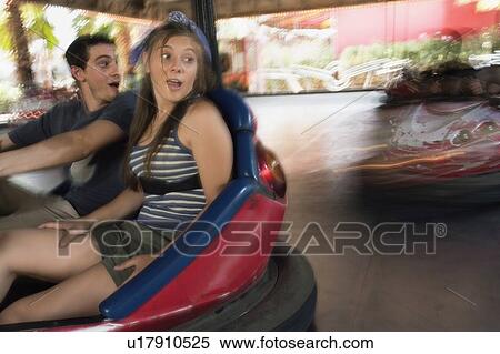 Stock Photography - Teenage couple in bumper car in amusement park. Fotosearch