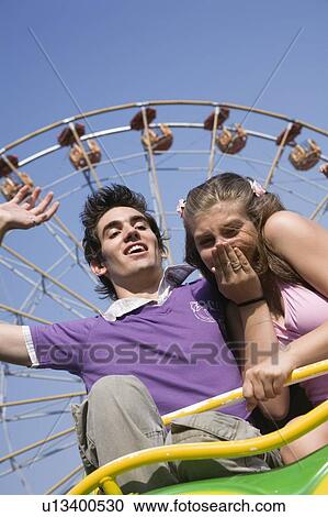 Teenage couple on amusement park ride View Large Photo Image Stock Image - Teenage couple on amusement park ride. Fotosearch