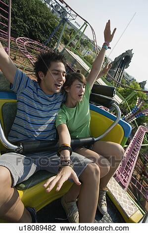 Stock Image - Teenage couple on amusement park ride. Fotosearch