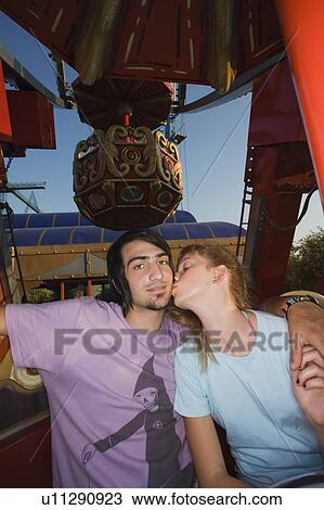 Teenage couple on Ferris wheel in amusement park View Large Photo Image Stock Image - Teenage couple on Ferris wheel in amusement park. Fotosearch