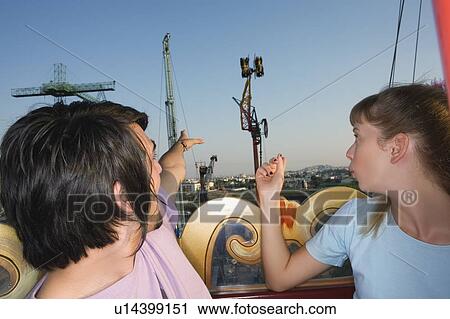 Teenage couple on Ferris wheel in amusement park View Large Photo Image Stock Image - Teenage couple on Ferris wheel in amusement park. Fotosearch