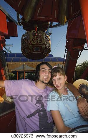 Teenage couple on Ferris wheel in amusement park View Large Photo Image Stock Image - Teenage couple on Ferris wheel in amusement park. Fotosearch