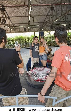 Teenage couple posing for a picture in bumper car in amusement park View Large Photo Image Stock Image - Teenage couple posing for a picture in bumper car in amusement park. Fotosearch