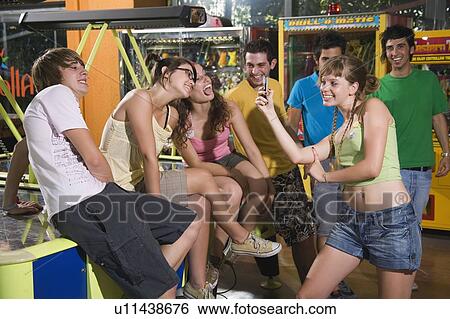 Teenagers hanging out at game in arcade View Large Photo Image Stock Photograph - Teenagers hanging out at game in arcade. Fotosearch