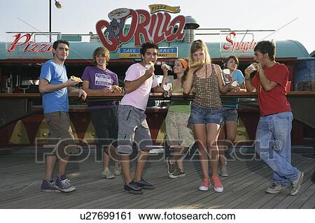 Stock Image - Teenagers hanging out, eating fast food. Fotosearch