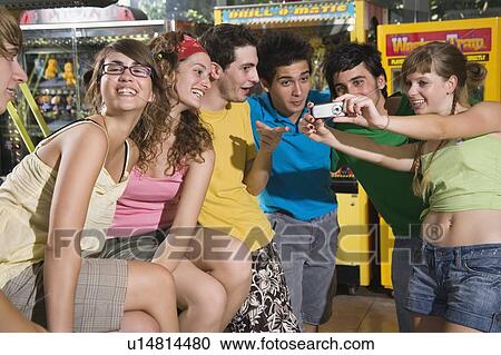 Stock Image - Teenagers hanging out in arcade. Fotosearch