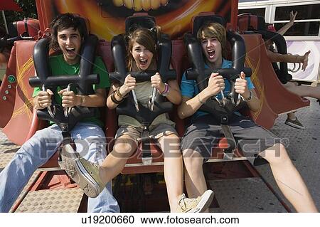 Stock Image - Teenagers on amusement park ride. Fotosearch