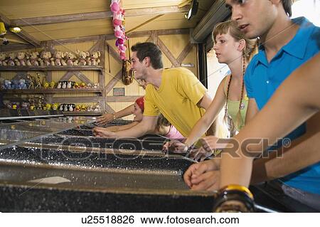 Teenagers playing game in amusement park View Large Photo Image Stock Photograph - Teenagers playing game in amusement park. Fotosearch