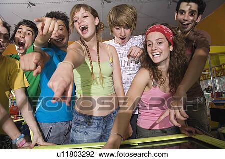 Teenagers playing game in arcade View Large Photo Image Stock Image - Teenagers playing game in arcade. Fotosearch