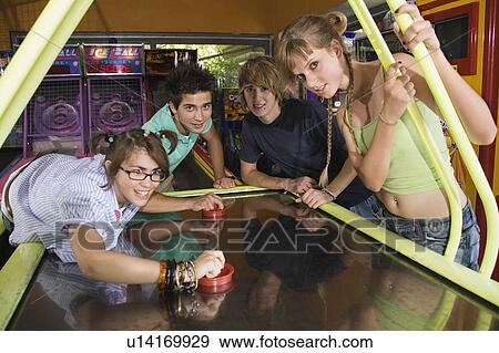 Teenagers playing game in arcade View Large Photo Image Stock Photo - Teenagers playing game in arcade. Fotosearch