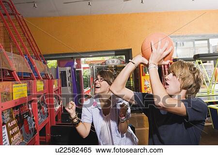 Teenagers playing game in arcade View Large Photo Image Stock Photography - Teenagers playing game in arcade. Fotosearch